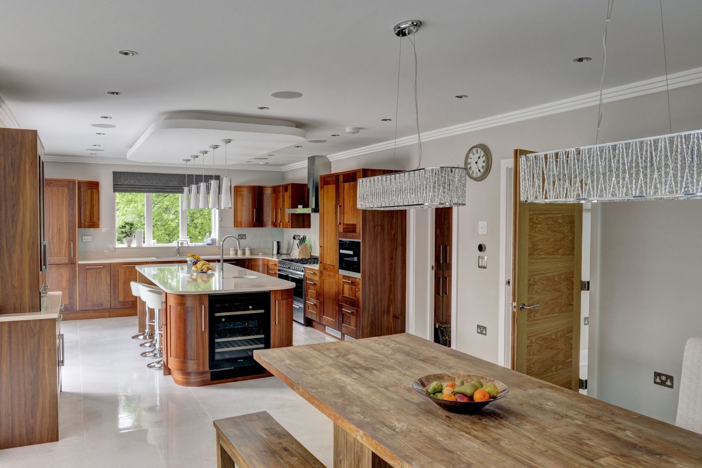 Walnut kitchen with an island and a long oak dining table