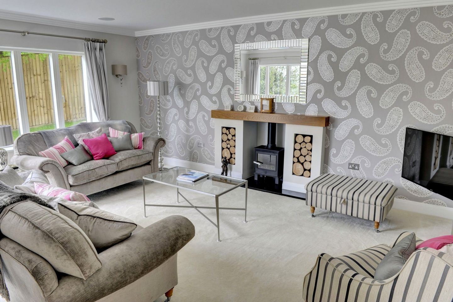 Living room with paisley wallpaper and a wood-burning stove